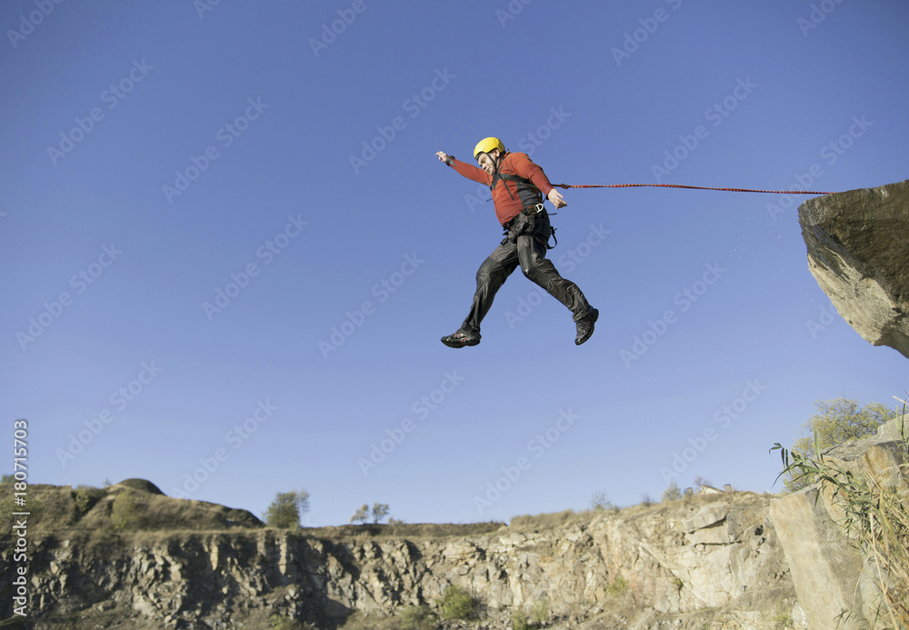 A man jumps into the abyss against the sky. A man jumps into the abyss against the sky.