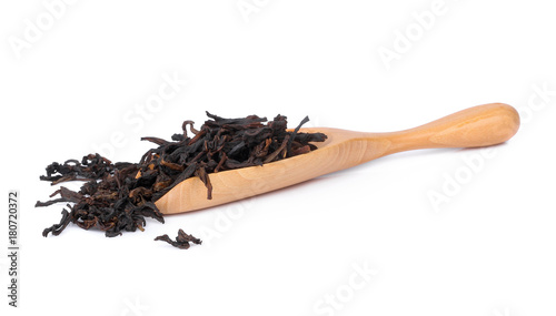 Dry tea in wood scoop on white background.