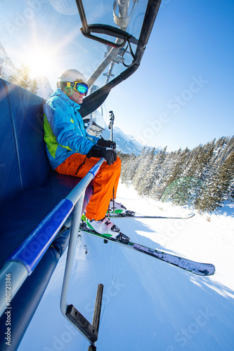 Skier sitting at ski lift.