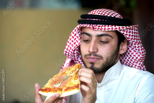 Photography Young muslim guy having pizza