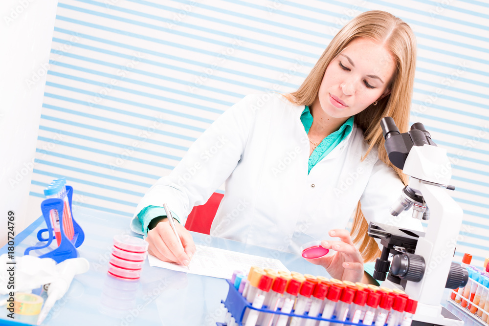 laboratory assistant examines the results of bio chemical tests
