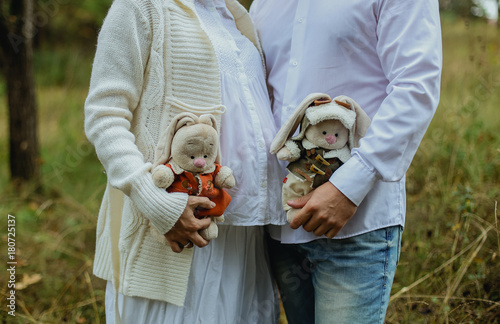 Fototapeta Naklejka Na Ścianę i Meble -  Pregnant woman holding her tummy toy rabbit