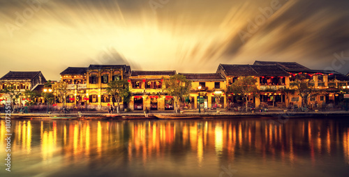 Street view with traditional boats on a background of ancient town in Hoi An Vietnam photo