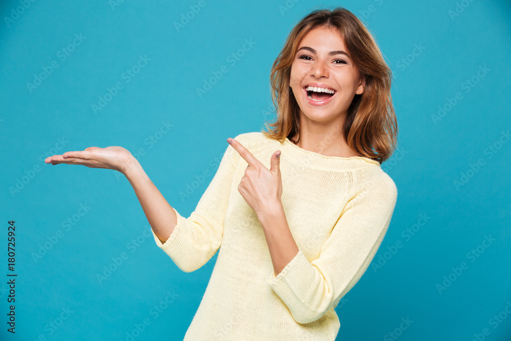 Laughing woman in sweater holding copyspace on the palm Laughing woman in sweater holding copyspace on the palm