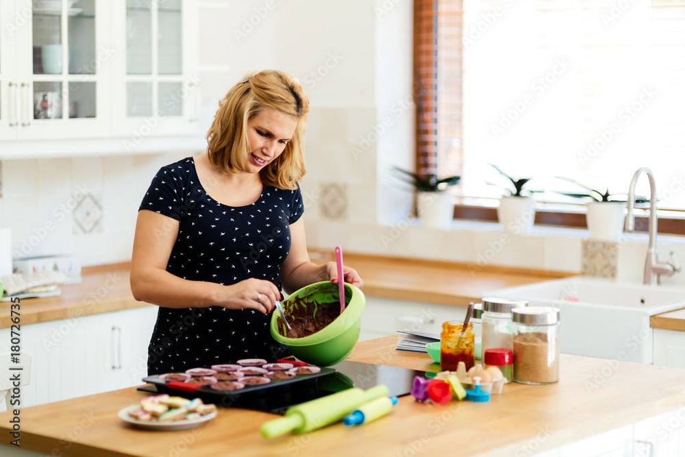 Beautiful pregnant woman preparing muffins Beautiful pregnant woman preparing muffins