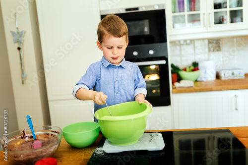 Child helping mother make muffins