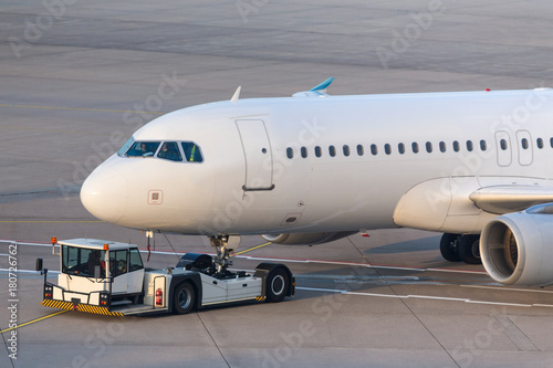 passenger airplane beeing towed at an airport