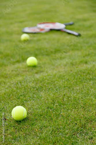 Racket and balls for tennis on green grass