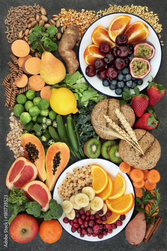 Healthy high fibre dietary food concept including fruit, vegetables, legumes, nuts, whole wheat pasta and whole grain bread rolls. High in antioxidants, omega 3 and vitamins.