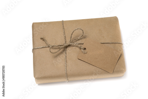 Christmas or New Year gift box wrapped in kraft paper with blank gift tag.