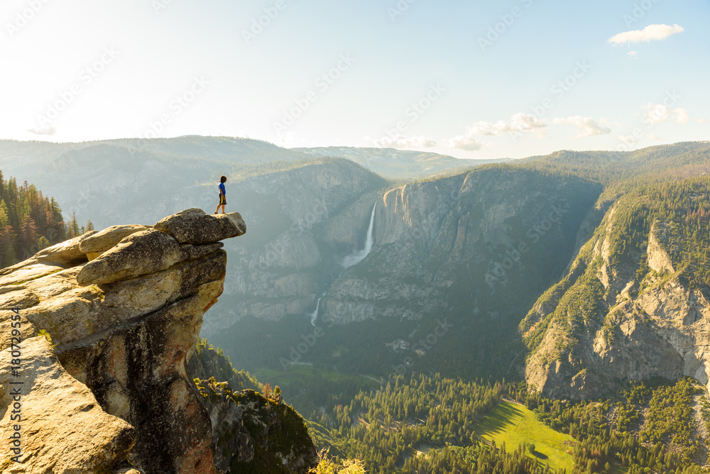 Fototapeta premium Wycieczkowicz w punkcie lodowca z widokiem na wodospady i dolinę Yosemite w Parku Narodowym Yosemite w Kalifornii, USA