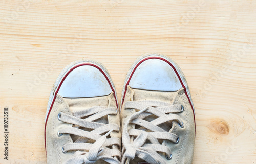 Old sneakers on wooden floor background and have copy space for design in your work.