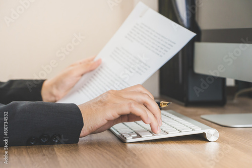 Business woman working at office with computer and documents on her desk, push button enter on keyborad , business concept