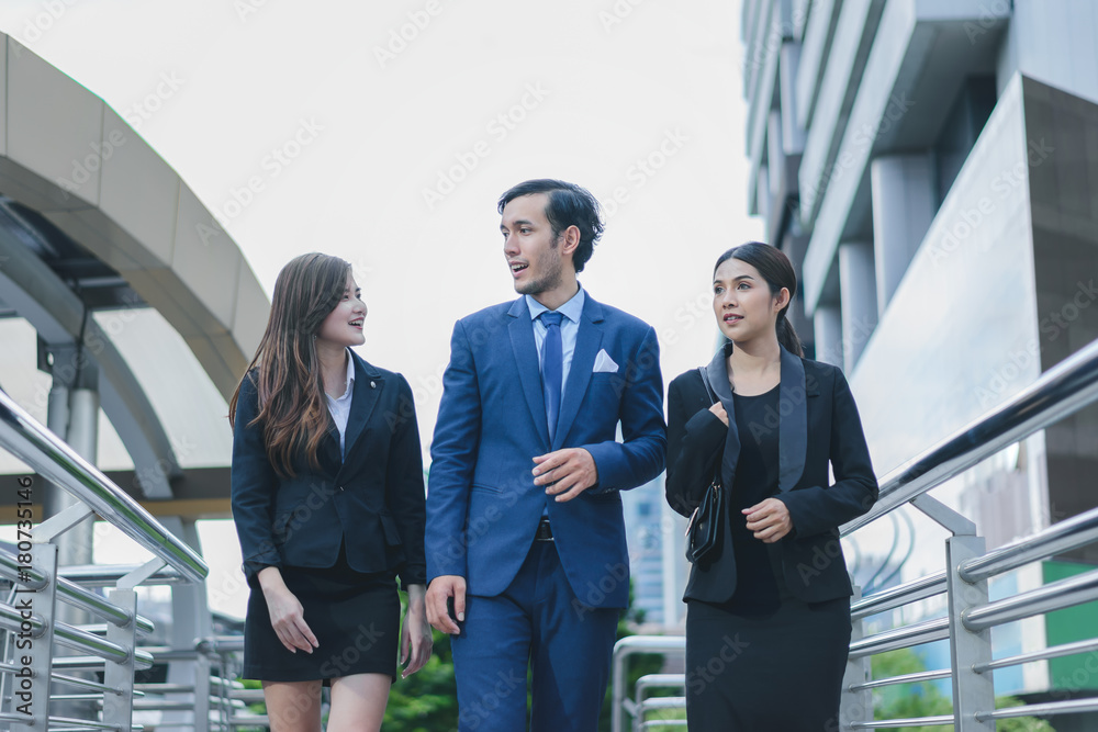 Professional business team walking forward confidently in cityscape background Professional business team walking forward confidently in cityscape background