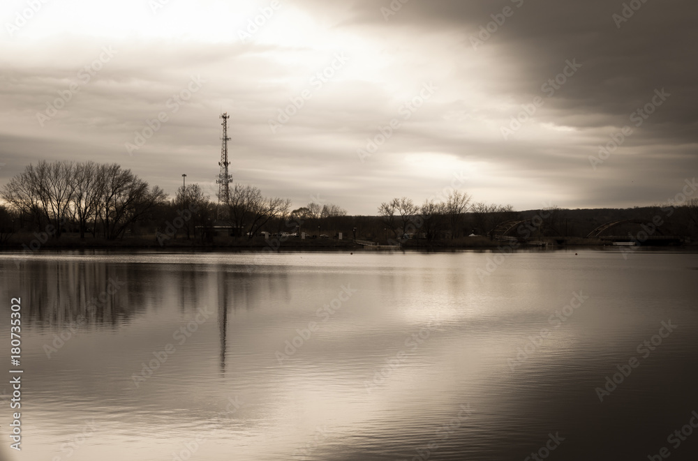 Lake background with moody cloud and sky water reflection. River front with bridge background. Cellular radio tower with overcast moody sky background. Parks and recreation outdoor design. 