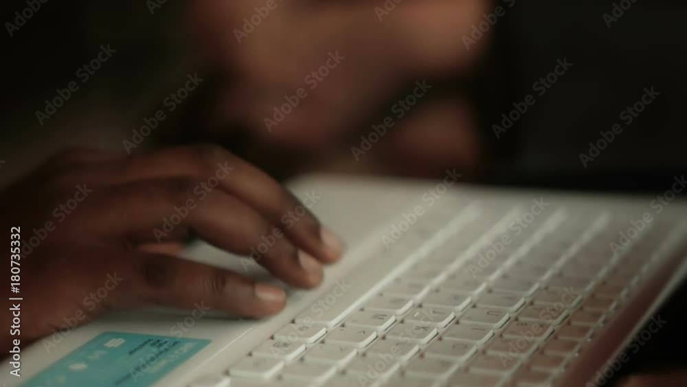 African American hand typing on computer keyboard. Cinematic depth of field. African American hand typing on computer keyboard. Cinematic depth of field.