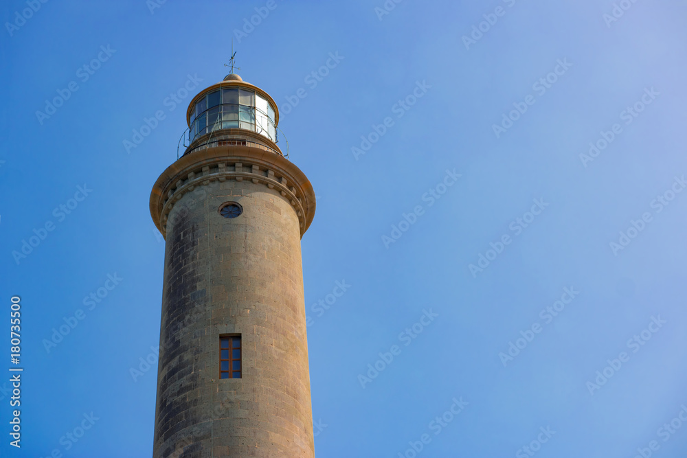 The top of the old Maspalomas Lighthouse against a clear blue sky with copyspace