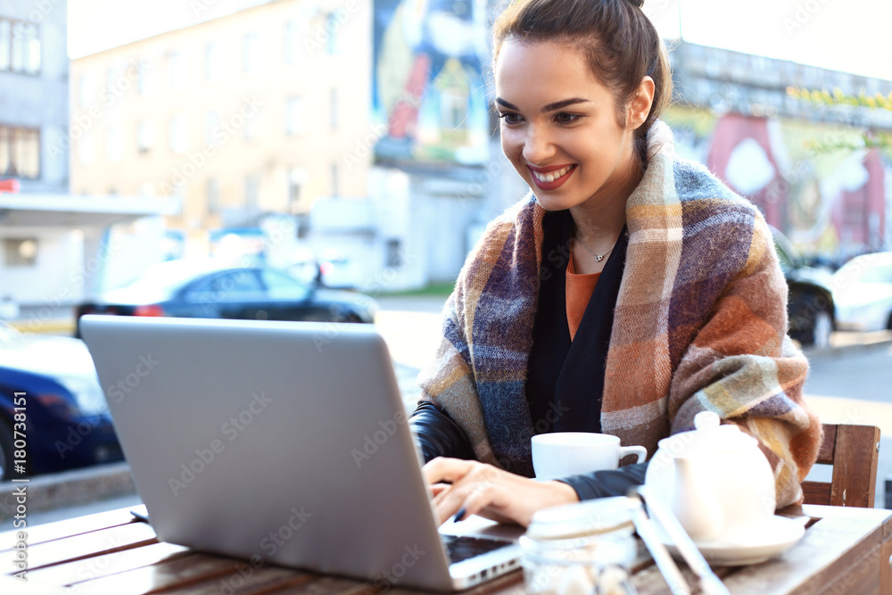 Beautiful brunette using notebook in cafe