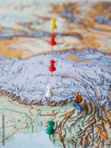 Miniature people with traveling concepts,riding bicycle on world map.