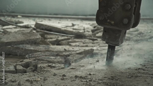 Dismantling the concrete floor: demolition machine destroys the concrete coating, close-up. Repair work with the special equipment: machine for dismantling. Drilling. No people