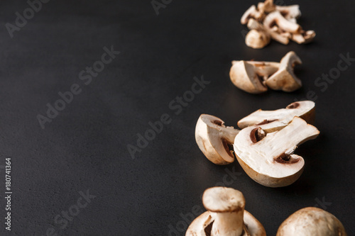 Stages of cutting mushrooms on black background, copy space, cooking backgroung.