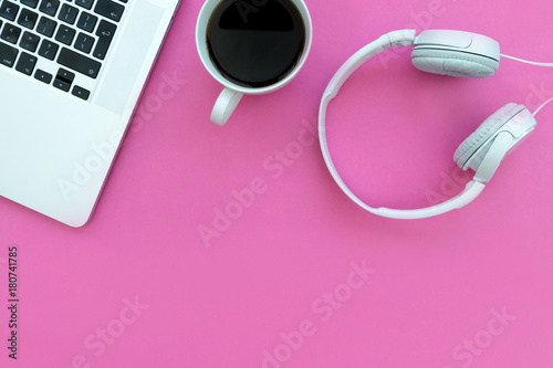Music headphones computer keyboard laptop + coffee on pink background