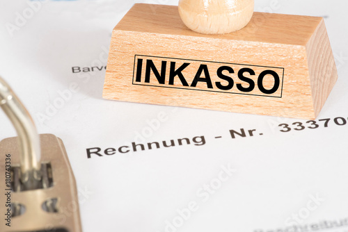 Eine Rechnung und ein Stempel mit dem Aufdruck Inkasso photo