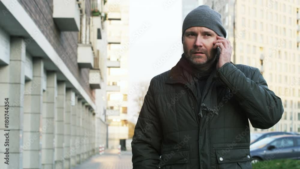 Middle-Aged Man Starting a Phone Call in the Street Middle-Aged Man Starting a Phone Call in the Street