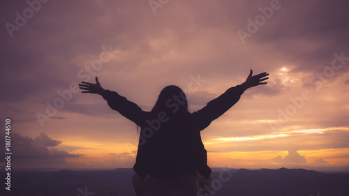 Silhouette freedom woman rise hands up to welcome a good day , open arms motivate enjoy and success the wish