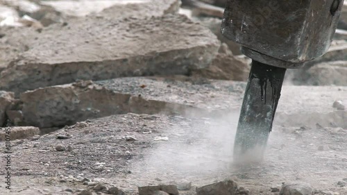 Professional electric tools for breaking the concrete cover. Clay digger in the process of work: close-up. Perforator for the destruction of concrete. Cracks on the floor from the work of a jackhammer photo