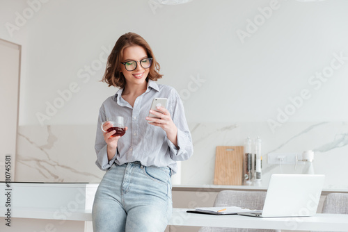 Fotografie Portrait of a happy attractive woman using mobile phone