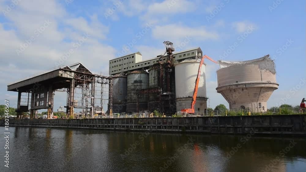 Mechanical jaws grabbing and breaking up a concrete industrial tank on a large site. Mechanical jaws grabbing and breaking up a concrete industrial tank on a large site.