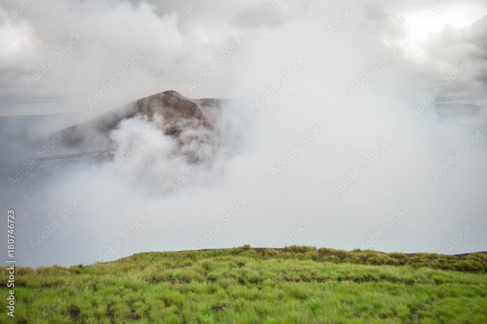 Fototapeta premium Very active heavily fuming crater of the Masaya Nindiri volcanic duo in Nicaragua. Dramatic sky. Central America