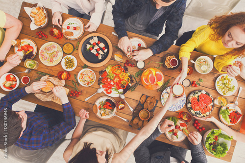 People eat and share healthy meals at served table dinner party