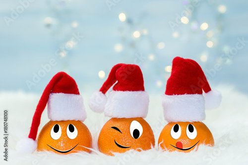 Christmas background with tangerines in Santa Claus hat. Funny characters from the original idea of the concept.
