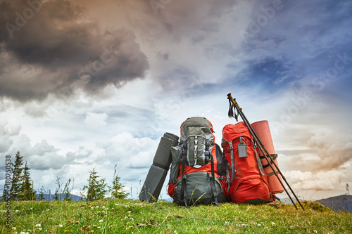 Backpacks in the mountains overlooking the mountains on the green grass. photo