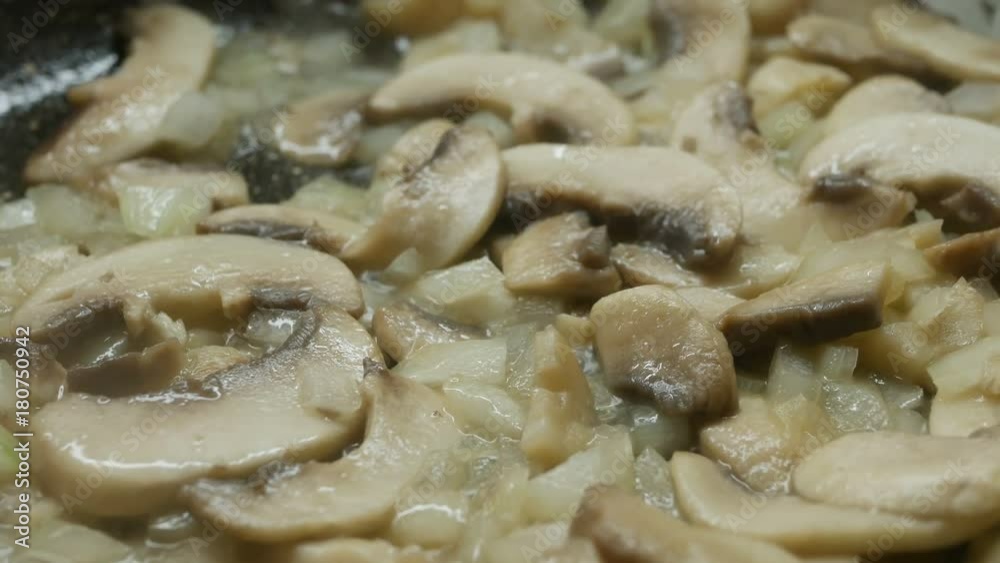 Mushrooms and onion frying on a pan, close-up Mushrooms and onion frying on a pan, close-up