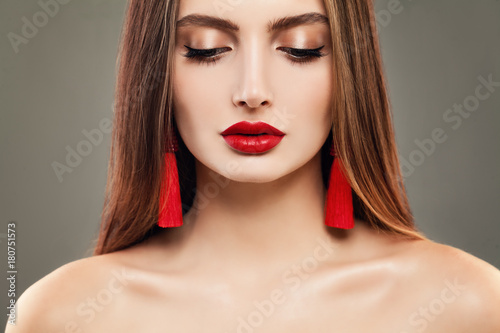 Young Woman with Red Lips Makeup and Jewelry Earrings. Beautiful Model, Cute Face