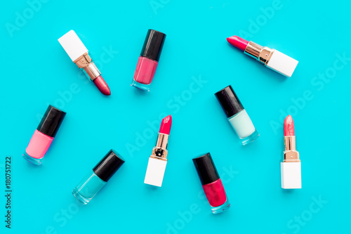 Decorative cosmetics concept. Lipsticks assorted colors and nail polish on blue background top view