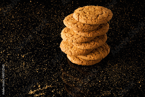 Oatmeal cookies with crumbs, isolated on a black background