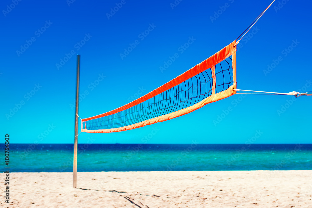 Volleyball net and empty beach. Sea Beach and Soft wave of blue ocean. Summer day and sand background. . Volleyball net and empty beach. Sea Beach and Soft wave of blue ocean. Summer day and sand background. .