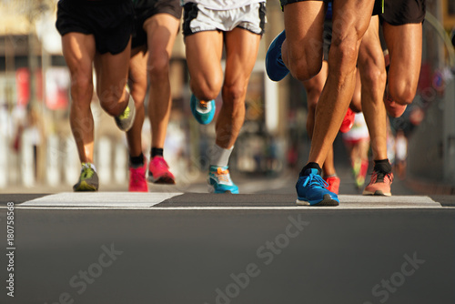 Marathon runners running on city road,detail on legs