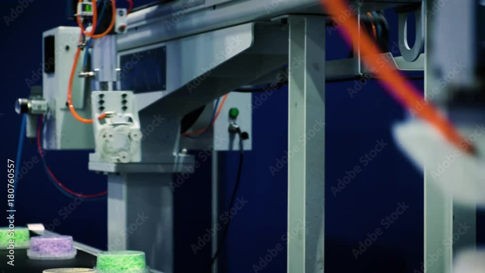 The mechanical arm of the robot works on the conveyor of food production. Fits boxes with food on a conveyor belt. The mechanical arm of the robot works on the conveyor of food production. Fits boxes with food on a conveyor belt.