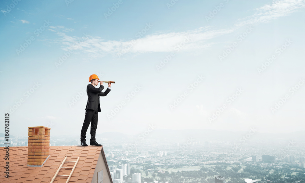 Engineer man standing on roof and looking in spyglass. Mixed media Engineer man standing on roof and looking in spyglass. Mixed media