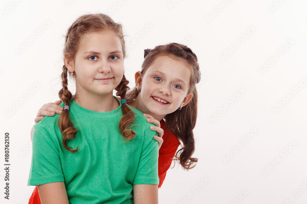 Two happy teenage girls hugging each other isolated on white background Two happy teenage girls hugging each other isolated on white background