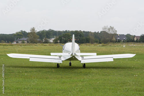 white airplane landed on a grassy airfield