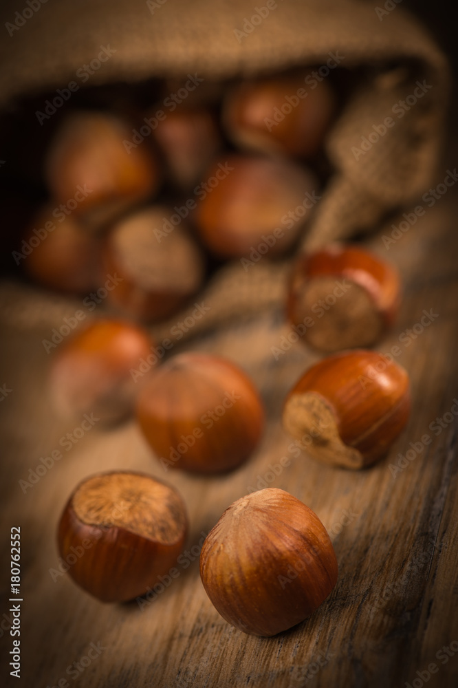 Hazelnuts and jute bag on rustic wooden background Hazelnuts and jute bag on rustic wooden background