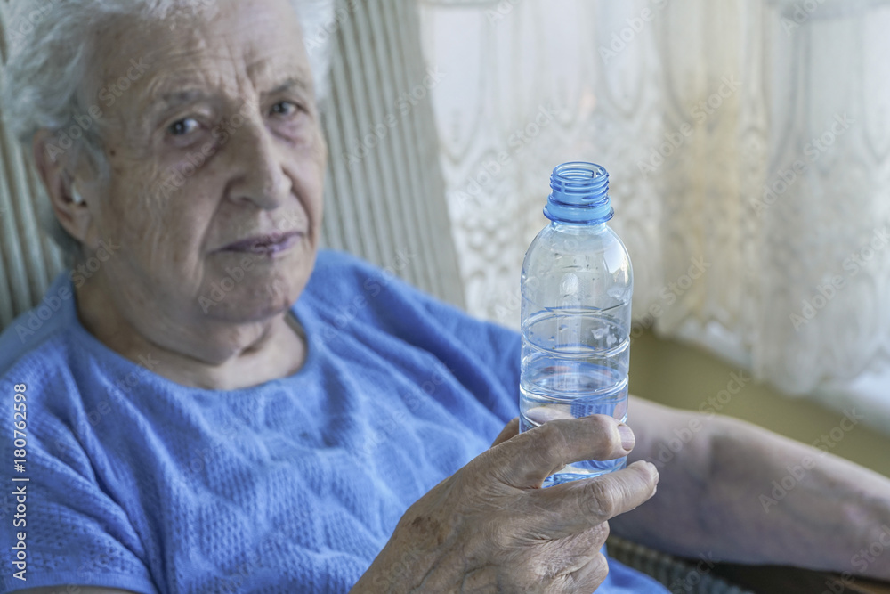 senior woman holding a bottle of drinking water senior woman holding a bottle of drinking water