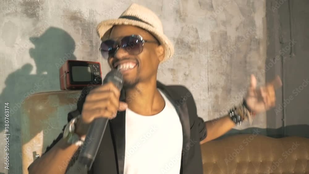 An African man is singing into the microphone. Record a music video. An African man is singing into the microphone. Record a music video.