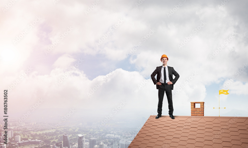 Engineer man standing on roof and looking away. Mixed media Engineer man standing on roof and looking away. Mixed media